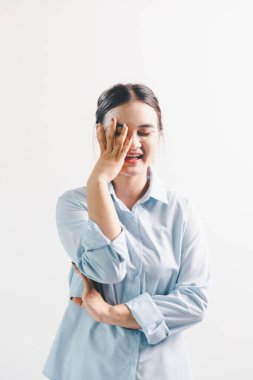 Asyalı bir kadın seviniyor, mutlu görünüyor, şampiyon, yumruk sallıyor, beyaz arka planda duruyor. Genç bir kadının yüzünde mutlu, pozitif bir ifade vardı. Parlak bir gülümsemeyle vurgulanmıştı..