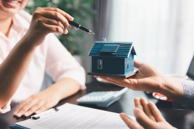 Kadın emlak satışı temsilcisi, emlak sözleşmesi imzaladıktan sonra mortgage kredi teklifi ve ev sigortası için onaylı emlak başvurusu formu imzalayan bir müşteri. Sözleşme imzalandı.