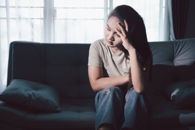 Boş karanlık odada kederli bir adam, elleri ile yüzünü kapatan depresif genç bir kadın. Üzüntülü yüzüyle başa çıkan genç bir kadın. Akıl sağlığı konsepti. Sıkıcı üzgün sinirli sinirli.