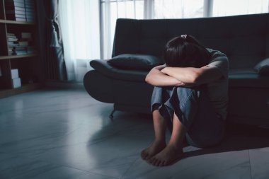 Depresyondaki kadın kanepeye oturur. Kederli insan yalnız başına oturur ve dizlerine sarılır sıkıcı üzgün üzgün sinirli sinirli. Boğucu bir yük altında umut bulmak için mücadele ediyorlar. ruh sağlığı kavramı.