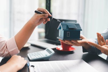 Kadın emlak satışı temsilcisi, emlak sözleşmesi imzaladıktan sonra mortgage kredi teklifi ve ev sigortası için onaylı emlak başvurusu formu imzalayan bir müşteri. Sözleşme imzalandı.