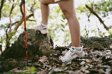Dağ çim patikasında yürüyüş. Kadın yürüyüşçü ayakkabısını kapat. Yürüyüşçülerin ve sırt çantalarının maceraperest yaşam tarzı seyahat ve dağ yürüyüşleri, her yürüyüşün ve heyecanlı yolculuğun her bölümünün tadını çıkar.