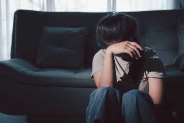 Boş karanlık odada kederli bir adam, elleri ile yüzünü kapatan depresif genç bir kadın. Üzüntülü yüzüyle başa çıkan genç bir kadın. Akıl sağlığı konsepti. Sıkıcı üzgün sinirli sinirli.