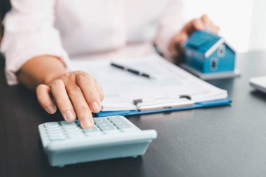 Yeniden finansman planı için konut kredisi harcamalarını kısmak ve kontrol etmek için hesap makinesi, insanların yaşam tarzı konsepti. Ev ajanları müşteri için her ay kredi sürelerini hesaplamak için hesap makinesi kullanıyorlar.