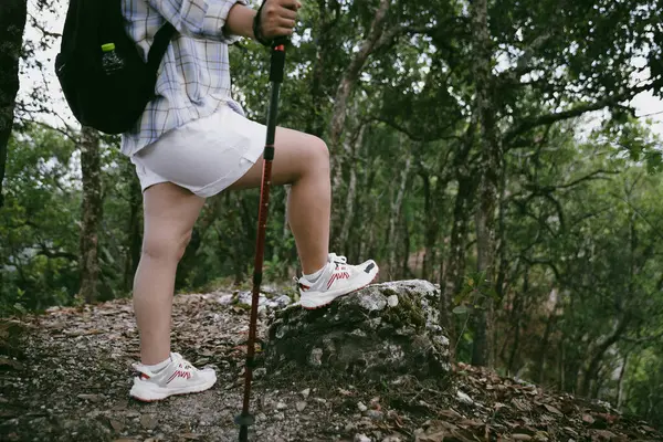 Dağ çim patikasında yürüyüş. Kadın yürüyüşçü ayakkabısını kapat. Yürüyüşçülerin ve sırt çantalarının maceraperest yaşam tarzı seyahat ve dağ yürüyüşleri, her yürüyüşün ve heyecanlı yolculuğun her bölümünün tadını çıkar.