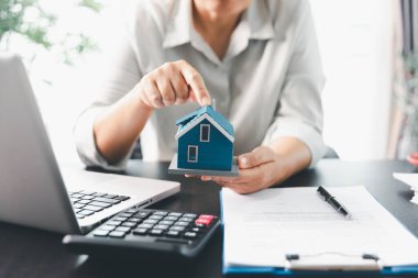 Emlakçı, müşteri temsilciliğine ev almayı kabul etti. Ev modeli, emlakçı, ev, sigorta, kredi emlak geçmişi için kontrat imzalamak isteyen müşteri. Kavram anlaşması.