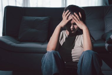 Boş karanlık odada kederli bir adam, elleri ile yüzünü kapatan depresif genç bir kadın. Üzüntülü yüzüyle başa çıkan genç bir kadın. Akıl sağlığı konsepti. Sıkıcı üzgün sinirli sinirli.