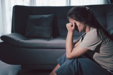 Boş karanlık odada kederli bir adam, elleri ile yüzünü kapatan depresif genç bir kadın. Üzüntülü yüzüyle başa çıkan genç bir kadın. Akıl sağlığı konsepti. Sıkıcı üzgün sinirli sinirli.