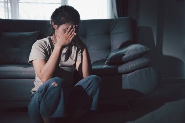 Boş karanlık odada kederli bir adam, elleri ile yüzünü kapatan depresif genç bir kadın. Üzüntülü yüzüyle başa çıkan genç bir kadın. Akıl sağlığı konsepti. Sıkıcı üzgün sinirli sinirli.