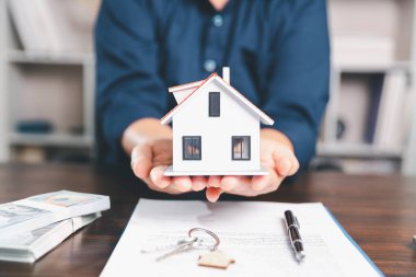 Model ev, yığınla para, hesap makinesi, ahşap masadaki mali belgeler emlak yatırımı ve ipotek planlama, mali büyüme ve stratejik planlama stratejilerini ön plana çıkarma.