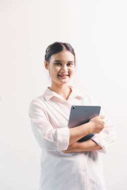 Asyalı bir kadın seviniyor, mutlu görünüyor, şampiyon, yumruk sallıyor, beyaz arka planda duruyor. Genç bir kadının yüzünde mutlu, pozitif bir ifade vardı. Parlak bir gülümsemeyle vurgulanmıştı..