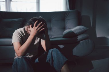 Boş karanlık odada kederli bir adam, elleri ile yüzünü kapatan depresif genç bir kadın. Üzüntülü yüzüyle başa çıkan genç bir kadın. Akıl sağlığı konsepti. Sıkıcı üzgün sinirli sinirli.