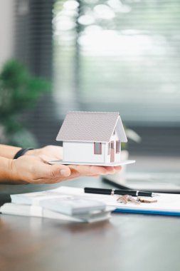 Para sikkelerinin yanına yerleştirilen ev modeli ev satın alma, yatırım, ipotek seçenekleri, konut kredileri, yeniden finanse etme, akıllı finans stratejileri için tasarruf ve mali planlama kavramını gözler önüne seriyor