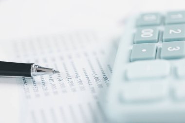 Denetçi, iş dünyası için ayrıntılı bir mali rapor hazırlamada muhasebe, denetim ve finans kavramını temsil eden bir hesap makinesi kullanarak mali beyanat ve bilançoyu masasında gözden geçirir..