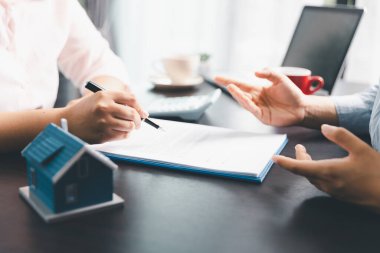 Kadın emlak satışı temsilcisi, emlak sözleşmesi imzaladıktan sonra mortgage kredi teklifi ve ev sigortası için onaylı emlak başvurusu formu imzalayan bir müşteri. Sözleşme imzalandı.