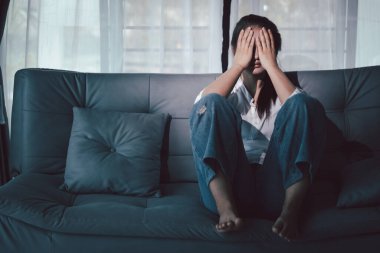 Boş karanlık odada kederli bir adam, elleri ile yüzünü kapatan depresif genç bir kadın. Üzüntülü yüzüyle başa çıkan genç bir kadın. Akıl sağlığı konsepti. Sıkıcı üzgün sinirli sinirli.