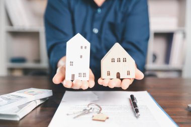 Model ev, yığınla para, hesap makinesi, ahşap masadaki mali belgeler emlak yatırımı ve ipotek planlama, mali büyüme ve stratejik planlama stratejilerini ön plana çıkarma.