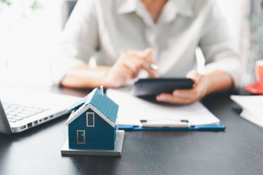 Emlakçı, müşteri temsilciliğine ev almayı kabul etti. Ev modeli, emlakçı, ev, sigorta, kredi emlak geçmişi için kontrat imzalamak isteyen müşteri. Kavram anlaşması.