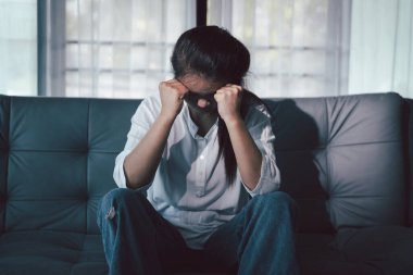 Boş karanlık odada kederli bir adam, elleri ile yüzünü kapatan depresif genç bir kadın. Üzüntülü yüzüyle başa çıkan genç bir kadın. Akıl sağlığı konsepti. Sıkıcı üzgün sinirli sinirli.