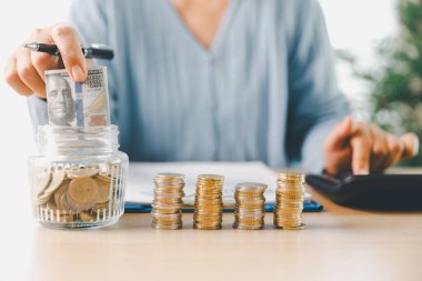 Elle para tasarruf kavanozuna konur, akıllı finans, yatırım, bankacılık uygulamalarının parayı, parayı, parayı, para birimini finansal zenginliğe dönüştürmesini ve iş büyümesini ve ekonomiyi nasıl güçlendirdiğini temsil eder..