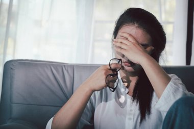 Boş karanlık odada kederli bir adam, elleri ile yüzünü kapatan depresif genç bir kadın. Üzüntülü yüzüyle başa çıkan genç bir kadın. Akıl sağlığı konsepti. Sıkıcı üzgün sinirli sinirli.