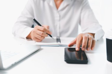 Yakın plan iş kadını ofis masasında akıllı cep telefonu kullanıyor, kız öğrenci evde online e-öğrenim okuyor, internette bilgi arıyor, sosyal ağlara bağlanıyor.