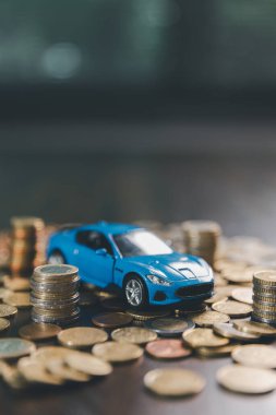 Avrupa araba finansmanı. Hesap makinesi ve paralı bir araba. Sigorta konsepti. Yatırım ve servet, madeni paraların yanı sıra minyatür arabanın sembolizmiyle birikiyor..