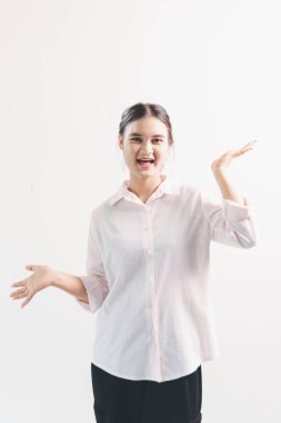 Asyalı bir kadın seviniyor, mutlu görünüyor, şampiyon, yumruk sallıyor, beyaz arka planda duruyor. Genç bir kadının yüzünde mutlu, pozitif bir ifade vardı. Parlak bir gülümsemeyle vurgulanmıştı..