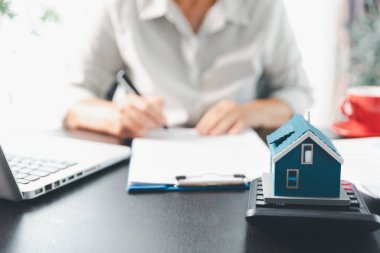 Emlakçı, müşteri temsilciliğine ev almayı kabul etti. Ev modeli, emlakçı, ev, sigorta, kredi emlak geçmişi için kontrat imzalamak isteyen müşteri. Kavram anlaşması.