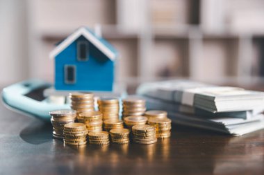 Model ev, yığınla para, hesap makinesi, ahşap masadaki mali belgeler emlak yatırımı ve ipotek planlama, mali büyüme ve stratejik planlama stratejilerini ön plana çıkarma.