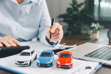 İş kadını araba sigortası belgesi ya da kira sözleşmesi imzalıyor. Sözleşmeye ya da anlaşmaya imza atmak. Yeni ya da kullanılmış araç almak ya da satmak. Arabanın anahtarları masanın üstünde. Garanti ya da garanti.