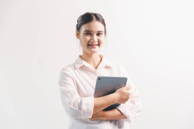 Asyalı bir kadın seviniyor, mutlu görünüyor, şampiyon, yumruk sallıyor, beyaz arka planda duruyor. Genç bir kadının yüzünde mutlu, pozitif bir ifade vardı. Parlak bir gülümsemeyle vurgulanmıştı..