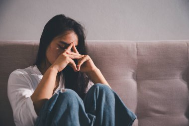 Boş karanlık odada kederli bir adam, elleri ile yüzünü kapatan depresif genç bir kadın. Üzüntülü yüzüyle başa çıkan genç bir kadın. Akıl sağlığı konsepti. Sıkıcı üzgün sinirli sinirli.