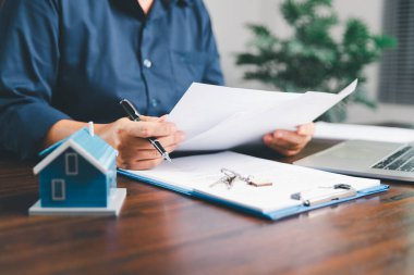 Kadın eli küçük minyatür bir oyuncak evi tutuyor, kendi emlak konseptine taşınma hayalini sembolize eden kadın emlak yatırımını, ipotek planlama, güvenli bir gelecek sigortasını temsil ediyor..