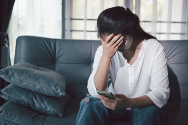 Boş karanlık odada kederli bir adam, elleri ile yüzünü kapatan depresif genç bir kadın. Üzüntülü yüzüyle başa çıkan genç bir kadın. Akıl sağlığı konsepti. Sıkıcı üzgün sinirli sinirli.