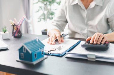 Emlakçı, müşteri temsilciliğine ev almayı kabul etti. Ev modeli, emlakçı, ev, sigorta, kredi emlak geçmişi için kontrat imzalamak isteyen müşteri. Kavram anlaşması.