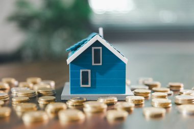 Model ev, yığınla para, hesap makinesi, ahşap masadaki mali belgeler emlak yatırımı ve ipotek planlama, mali büyüme ve stratejik planlama stratejilerini ön plana çıkarma.