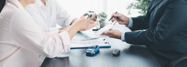 Araba kredisi anlaşmasıyla yapılan iş görüşmesinin panorama görüntüsü, ofis masasındaki müşterilere hesap makinesini araç modeli ve anahtarıyla gösteren dağıtıcı, otomobil finansmanı, kiralama veya sigorta kavramı. araba kredisi.