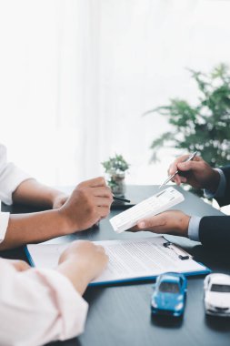 İş adamı araba kredisini hesap makinesiyle açıklıyor, müşteri ofis masasında oyuncak araba ve belgelerle otomobil finansmanı anlaşmasını tartışıyor, araç kredisi, sigorta veya araba kiralama kavramını anlatıyor. araba kredisi.