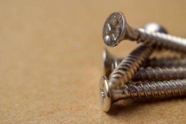 Vidalar, metal vidalar, demir vidalar, sarı arka planda izole ahtan vidalar