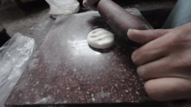Hintli bir kadının eli puri yapıyor. Düz ekmek pişirmek için hamur yoğurma, ellere yakın çekim. Hint 4K görüntülerinde belan 'la puri yapıyorlar.