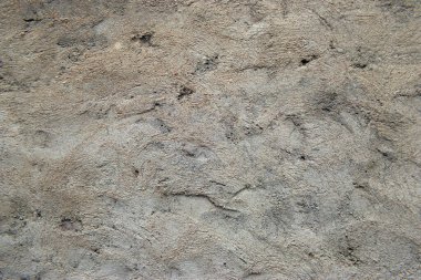 Koyu lekeli sert desenli bir beton duvar yüzeyi