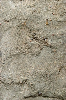 Koyu lekeli sert desenli bir beton duvar yüzeyi