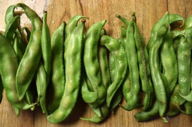 Taze Sümbül Fasulyesi Grubu ya da Ahşap Masadaki Aynı Ki Phalli Arka plan bulanıklığı ile Yakın plan