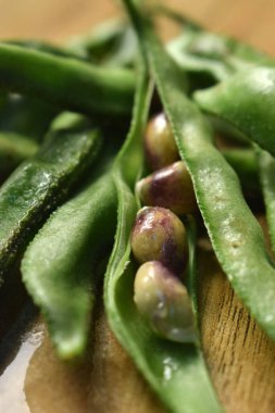 Taze Sümbül Fasulyesi Grubu ya da Ahşap Masadaki Aynı Ki Phalli Arka plan bulanıklığı ile Yakın plan