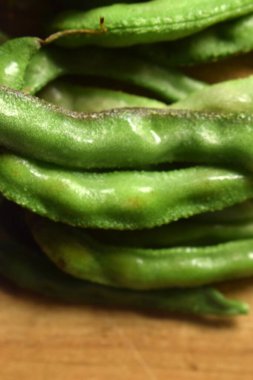 Taze Sümbül Fasulyesi Grubu ya da Ahşap Masadaki Aynı Ki Phalli Arka plan bulanıklığı ile Yakın plan