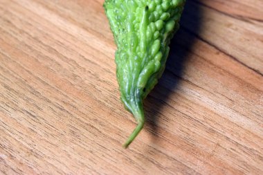 Taze yeşil karpuz ya da ahşap masa üzerindeki acı kabak. Arkaplan bulanıklığı ile yakın plan.