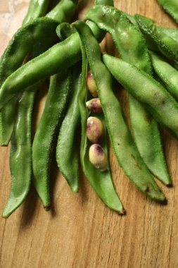 Taze Sümbül Fasulyesi Grubu ya da Ahşap Masadaki Aynı Ki Phalli Arka plan bulanıklığı ile Yakın plan