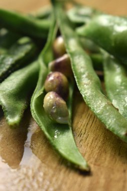 Taze Sümbül Fasulyesi Grubu ya da Ahşap Masadaki Aynı Ki Phalli Arka plan bulanıklığı ile Yakın plan