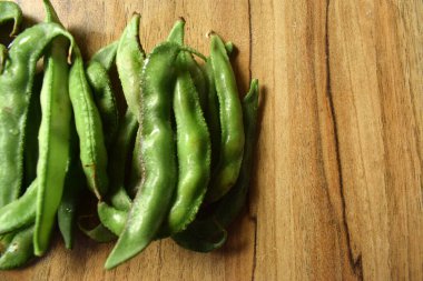 Taze Sümbül Fasulyesi Grubu ya da Ahşap Masadaki Aynı Ki Phalli Arka plan bulanıklığı ile Yakın plan